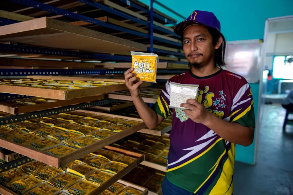 Mohd Fauzi Abdul Wafa memegang pek tempe di ruang pengeluaran Poji’s Tempe